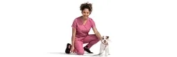 一位女兽医跪在一只狗旁边.